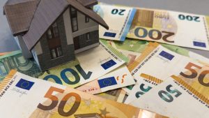 Een Afbeelding Van Een Huis Op Een Stapel Euro Bankbiljetten.jpg