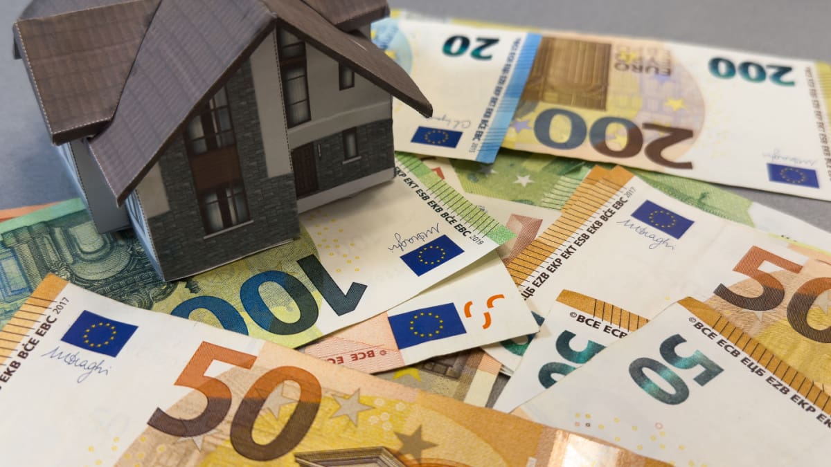 Een Afbeelding Van Een Huis Op Een Stapel Euro Bankbiljetten.jpg