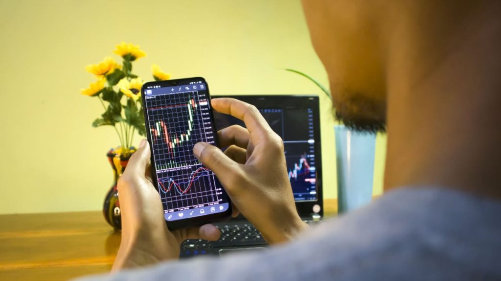 Een Afbeelding Van Een Stijgende Crypto Koers Op Een Mobiele Telefoon Die Door Een Amateur Handelaar.jpeg