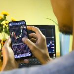 Een Afbeelding Van Een Stijgende Crypto Koers Op Een Mobiele Telefoon Die Door Een Amateur Handelaar.jpeg